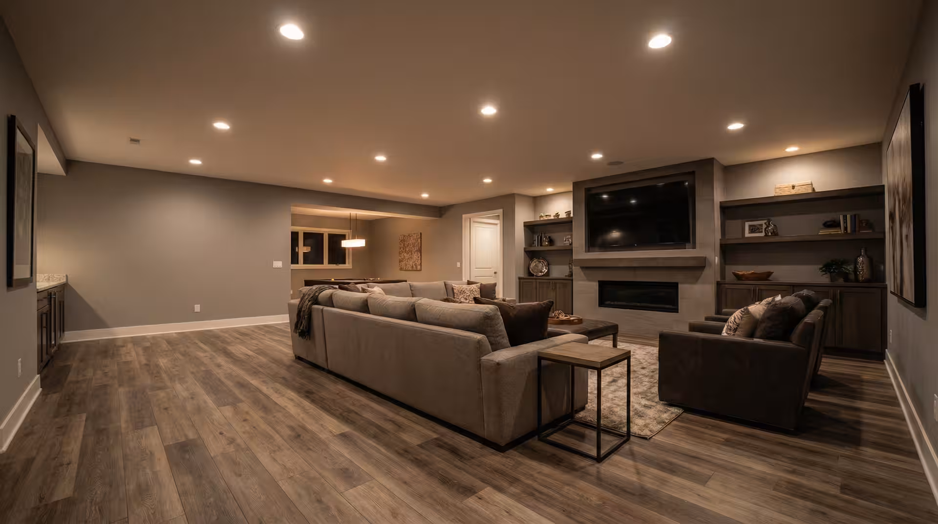 Finished Utah basement living area with fireplace, built-ins, and open floor plan