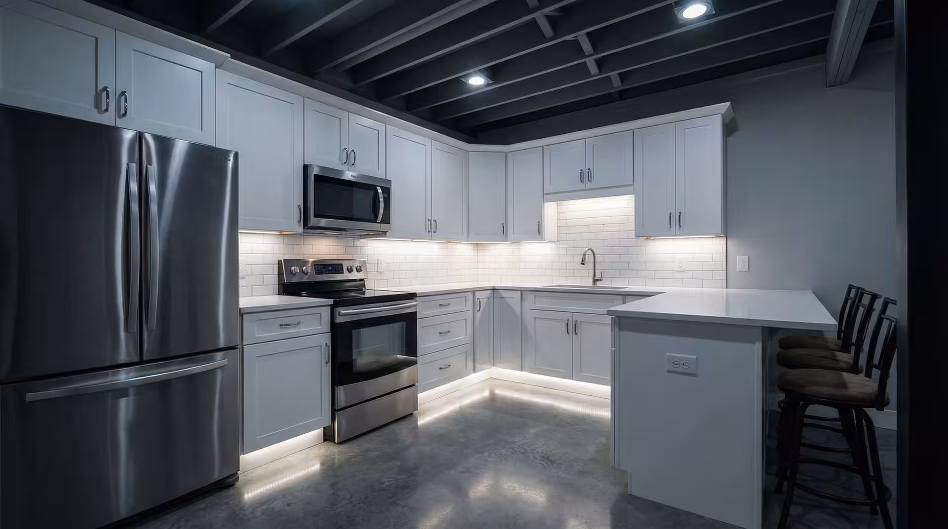 Finished Utah basement kitchenette with cabinets and island seating